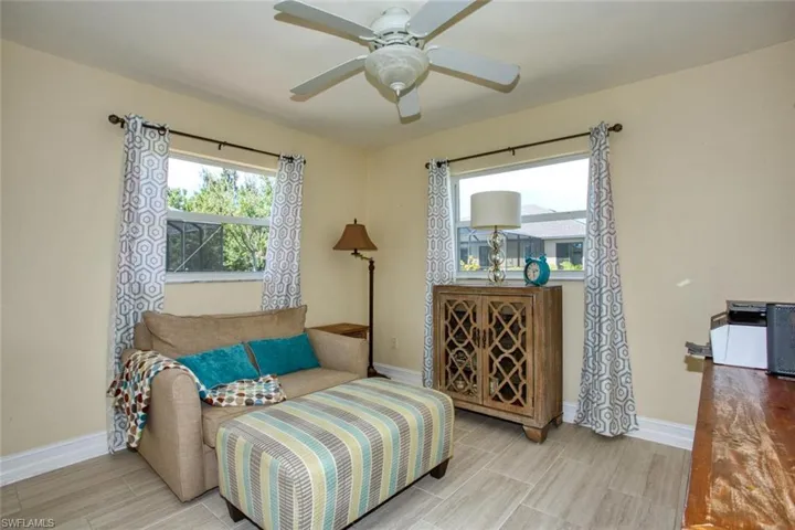 Living area with baseboards and a ceiling fan