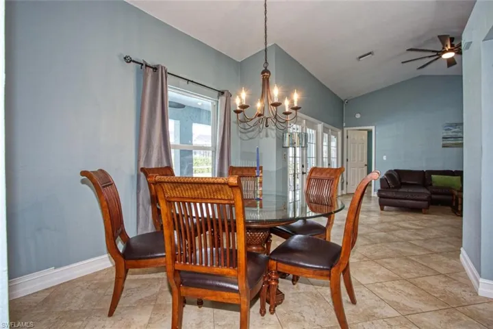 Dining area featuring a chandelier, lofted ceiling, and a ceiling fan