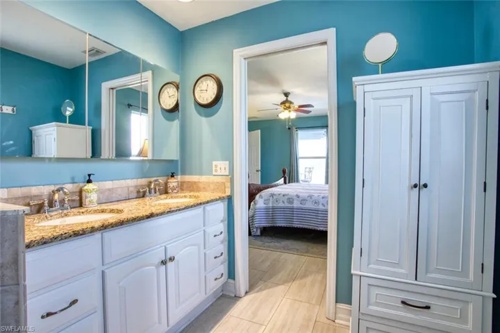 Ensuite bathroom with double vanity and a ceiling fan