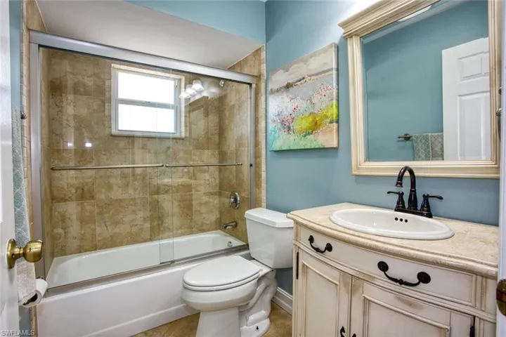 Full bath with vanity and shower / bath combination with glass door