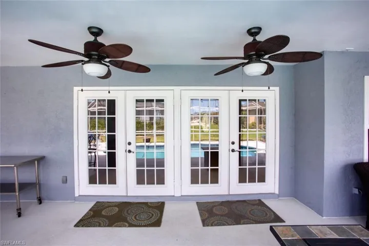 Doorway with french doors and ceiling fan