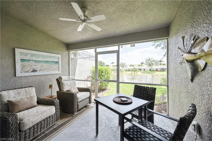Sunroom featuring ceiling fan and a water view