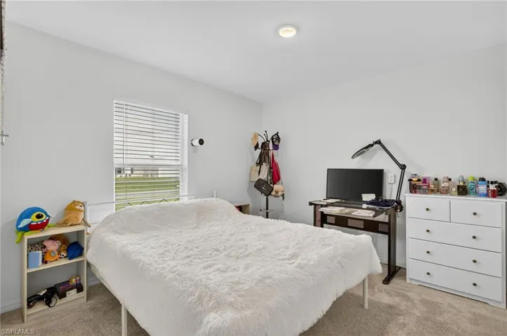 Bedroom featuring light carpet