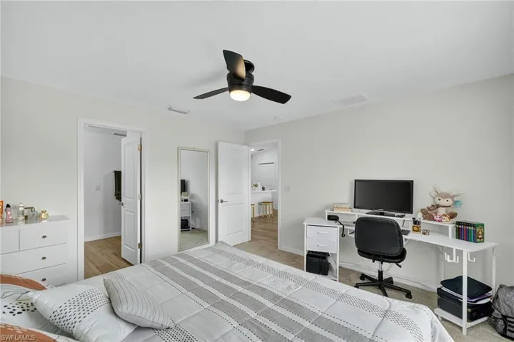 Bedroom with an office area and a ceiling fan
