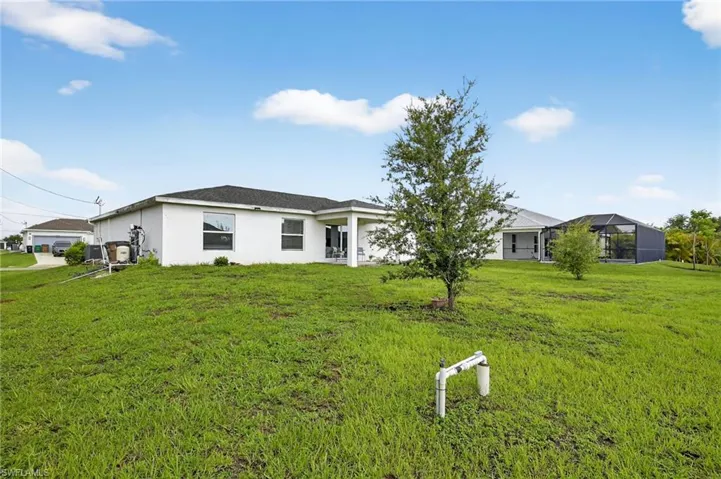 View of front of property featuring stucco siding and a front lawn