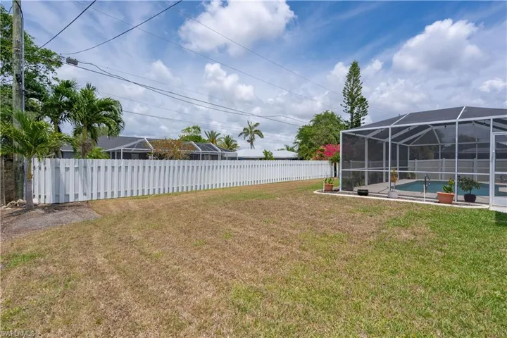 View of yard featuring glass enclosure and a patio