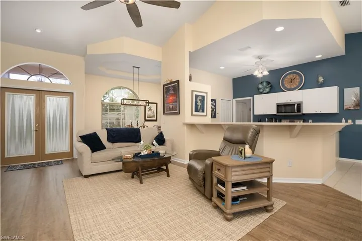 Living area with ceiling fan, baseboards, light wood-type flooring, and recessed lighting