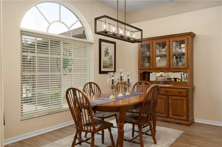 Dining room featuring light wood finished floors, baseboards, and healthy amount of natural light