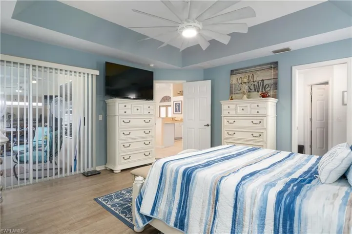 Bedroom with light wood finished floors, access to outside, baseboards, and ceiling fan
