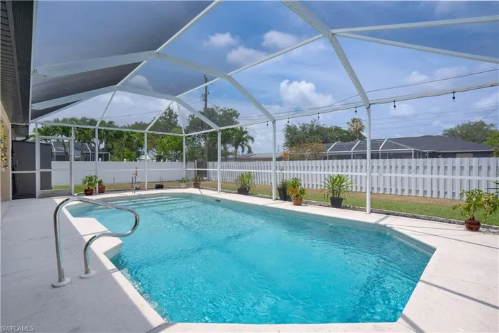 View of pool with a fenced backyard, a patio, and a lanai