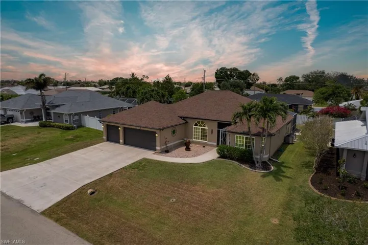 View of front of property featuring a garage, driveway, a residential view, a shingled roof, and stucco siding
