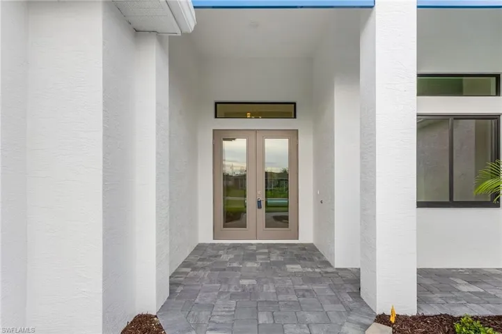 Property entrance featuring french doors and stucco siding