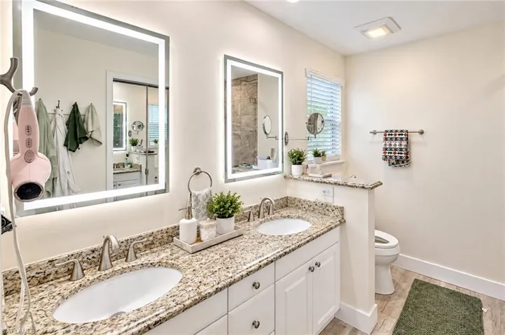 Dual vanity with undermount sinks, granite countertops, and illuminated mirrors