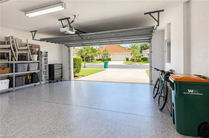 Epoxy-coated garage flooring with an automated garage door opener and overhead fluorescent lighting