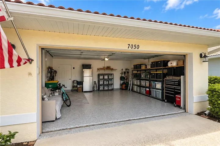 Garage with a finished floor and ample overhead lighting