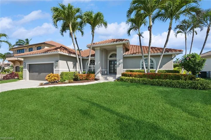 Mediterranean / spanish-style house featuring stucco siding, a front yard, a tile roof, an attached garage, and driveway