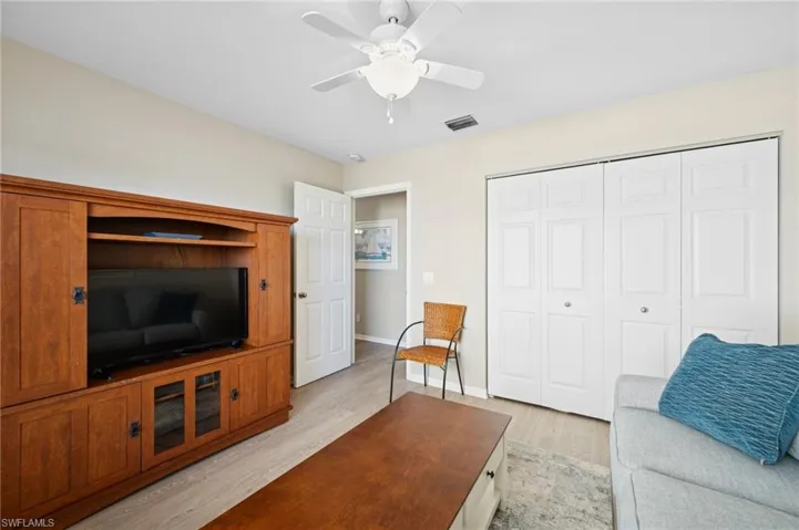 Living area featuring baseboards, visible vents, light wood-type flooring, and a ceiling fan