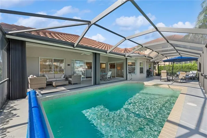View of pool with outdoor lounge area, a patio area, a lanai, and a covered pool
