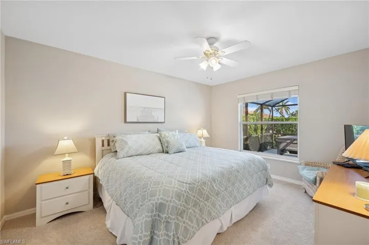 Bedroom with baseboards, ceiling fan, and light carpet