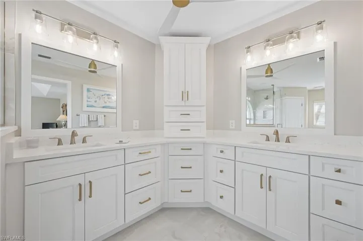 Full bath with marble finish floor, a shower with shower door, ceiling fan, and vanity