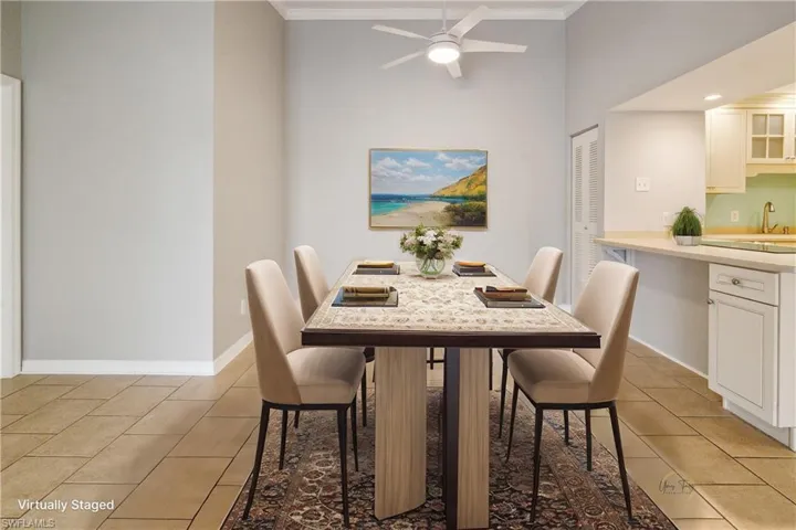 Dining area with ornamental molding, light tile patterned flooring, a ceiling fan, and baseboards