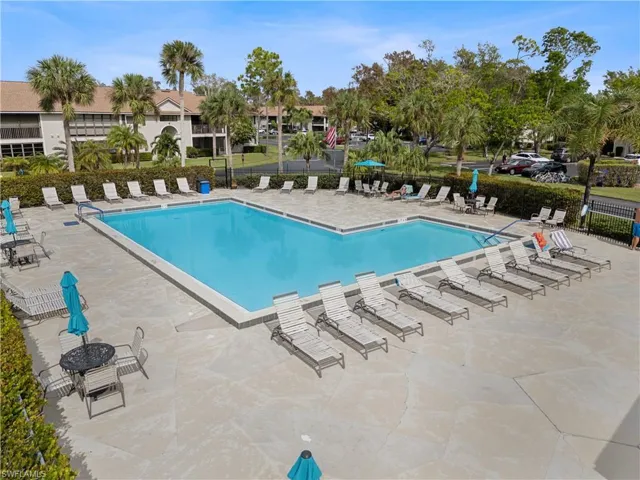 Community pool with a patio and fence