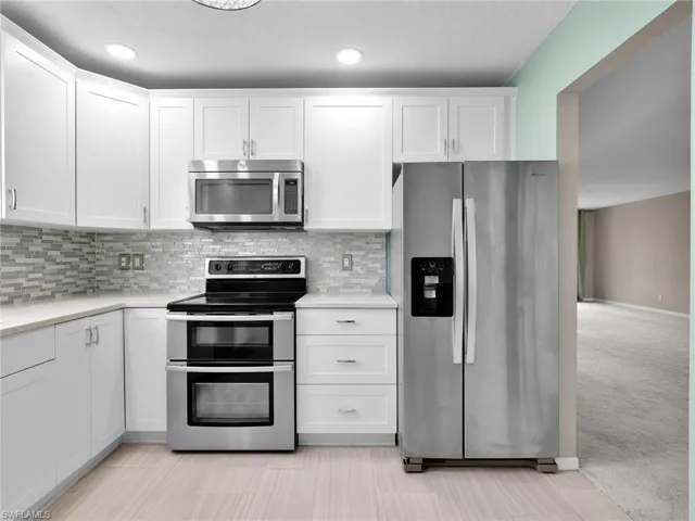Remodeled Kitchen with Stainless Steel Appliances, Single Basin Sink, Quartz Counters, and Tile Backsplash