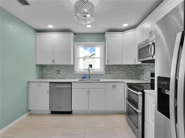 Remodeled Kitchen with Stainless Steel Appliances, Single Basin Sink, Quartz Counters, and Tile Backsplash
