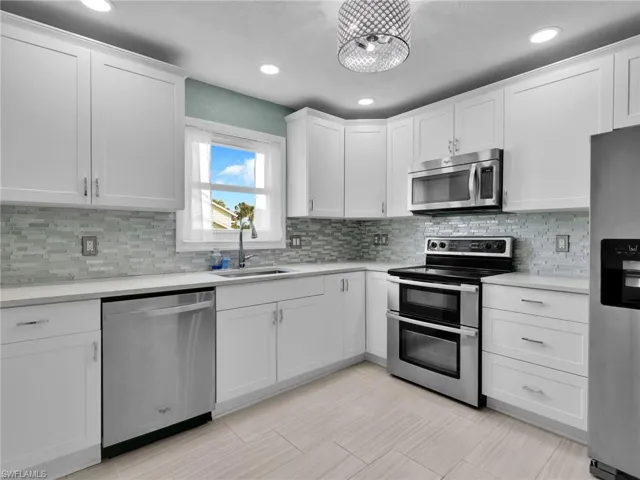 Remodeled Kitchen with Stainless Steel Appliances, Single Basin Sink, Quartz Counters, and Tile Backsplash