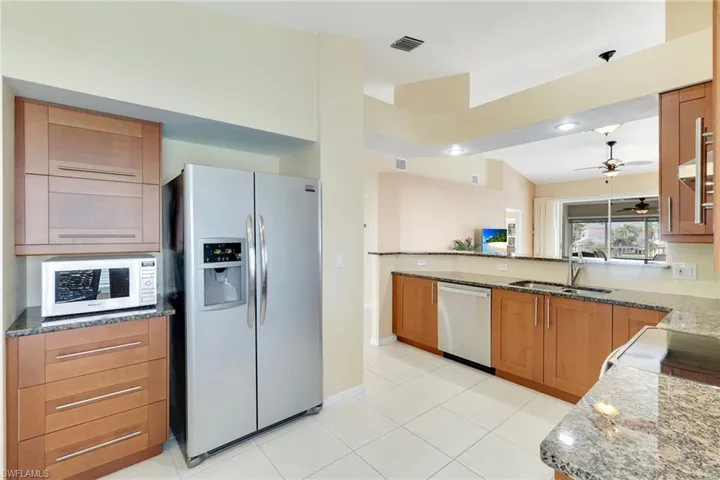 Modern open kitchen featuring granite countertops and stainless-steel appliances