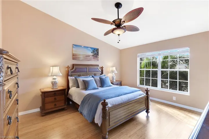 Furnished primary bedroom with wood floors and lake view