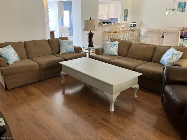 Living room with hardwood / wood-style flooring and an inviting chandelier