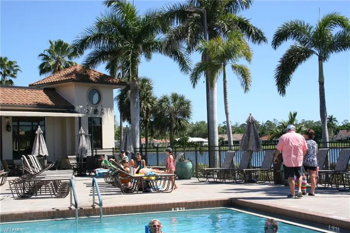 Community pool featuring a patio area and fence