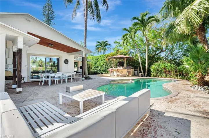 Swimming pool with a patio area, an outdoor bar, outdoor dining space, an outdoor kitchen, and outdoor lounge area