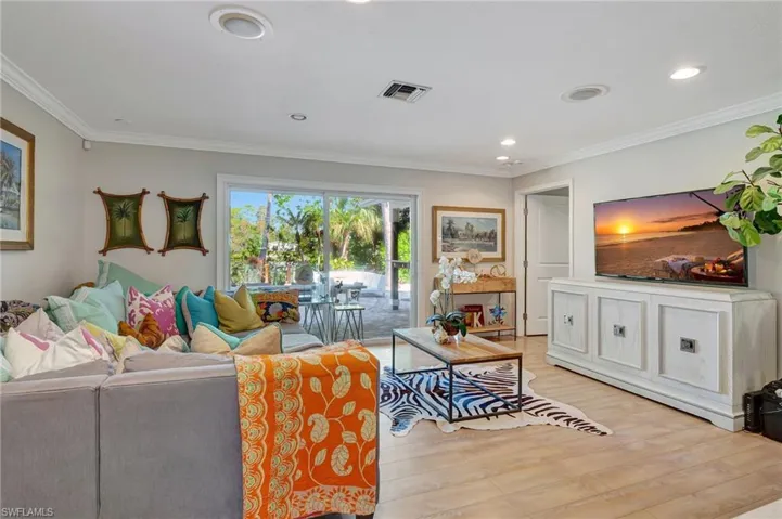 Living area with light wood-style flooring, crown molding, and recessed lighting