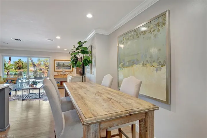 Dining space featuring wood finished floors, recessed lighting, and ornamental molding