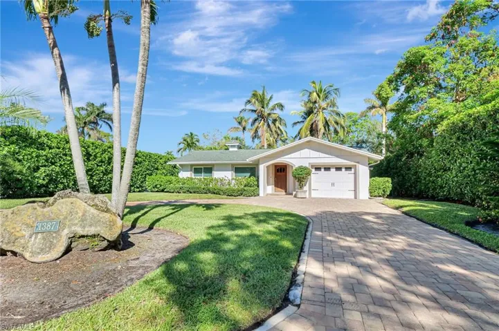 Single story home with a garage, a front yard, and decorative driveway