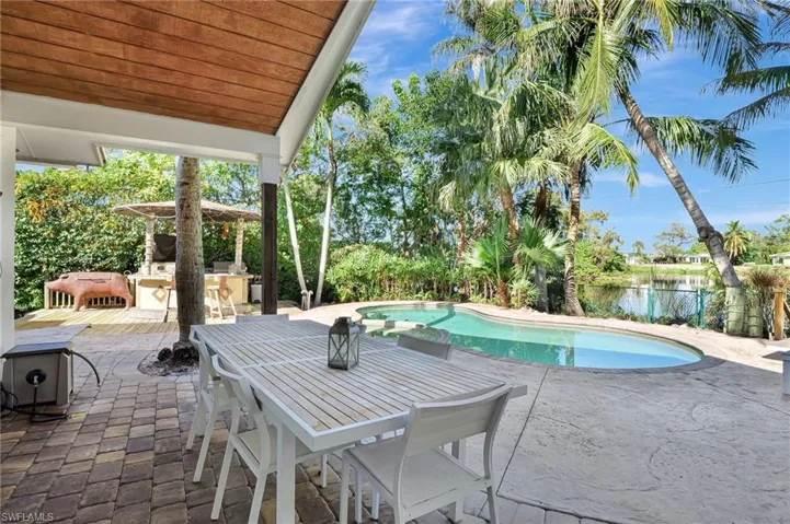 View of swimming pool with a patio and a water view