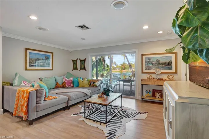 Living room featuring crown molding, light wood-type flooring, and recessed lighting