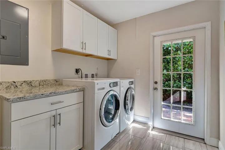 Laundry room with cabinet space, washer, dryer, and baseboards