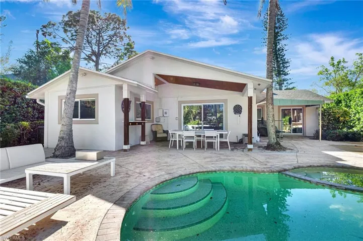 Back of property featuring a patio area, an outdoor pool, stucco siding, and an outdoor living space