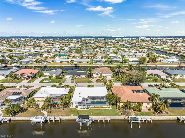 Aerial perspective of suburban area featuring a nearby body of water