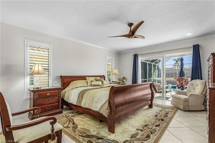 Bedroom featuring access to outside, a ceiling fan, light tile patterned floors, a textured ceiling, and ornamental molding