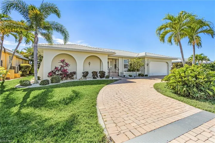 View of front of home featuring an attached garage, stucco siding, decorative driveway, a front yard, and a tile roof