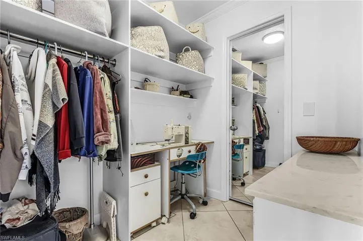 Walk in closet with light tile patterned floors