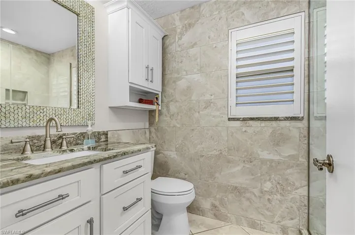 Bathroom with vanity, tile walls, and tile patterned flooring