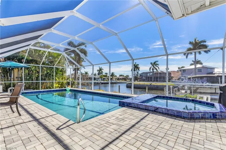View of swimming pool featuring a water view, a sunroom, a dock, and glass enclosure