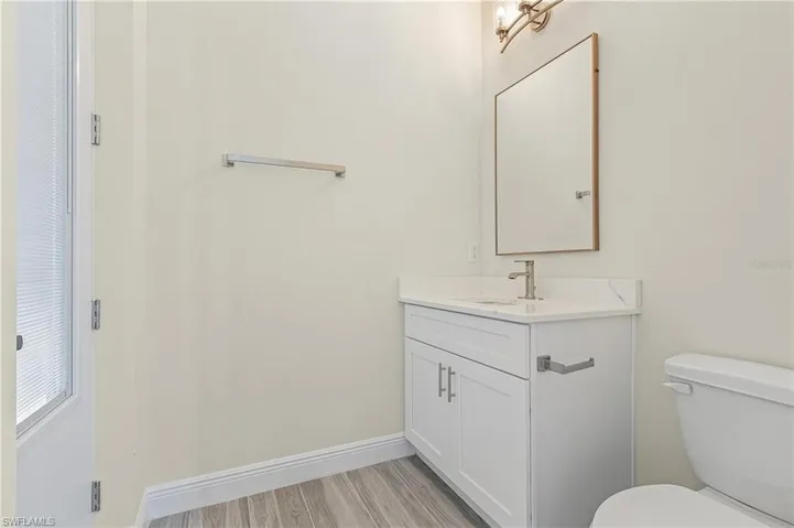 Bathroom with wood-type flooring, toilet, and vanity