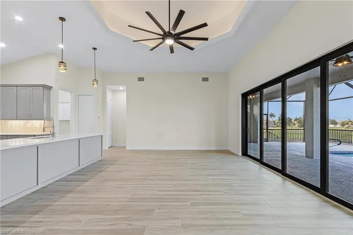 Kitchen featuring sink, pendant lighting, ceiling fan, and decorative backsplash