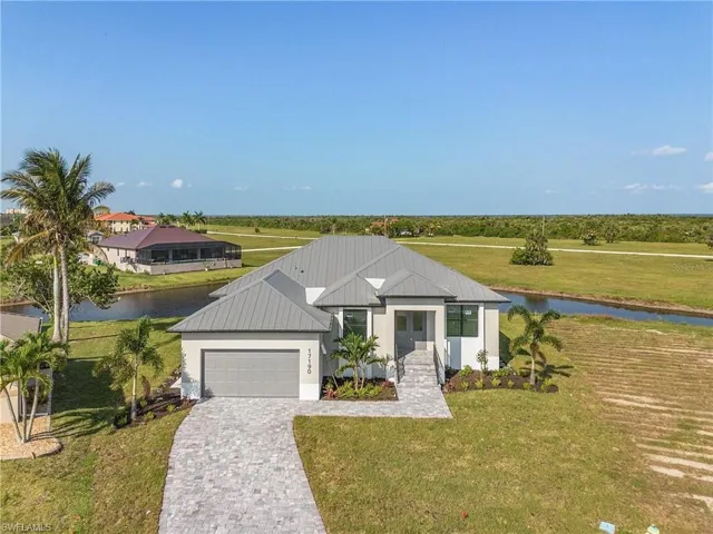 View of front facade with a garage, a water view, and a front yard
